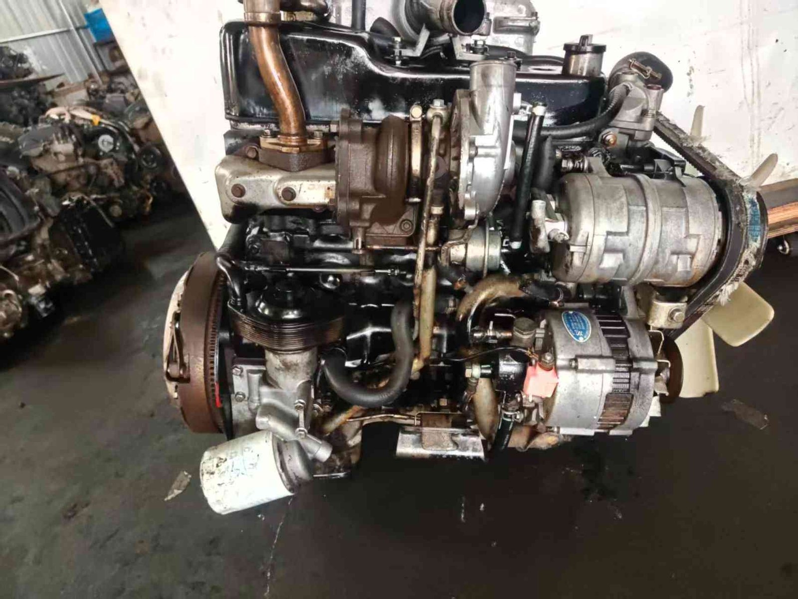 4JB1T turbocharged engine side with turbocharger, alternator and AC compressor