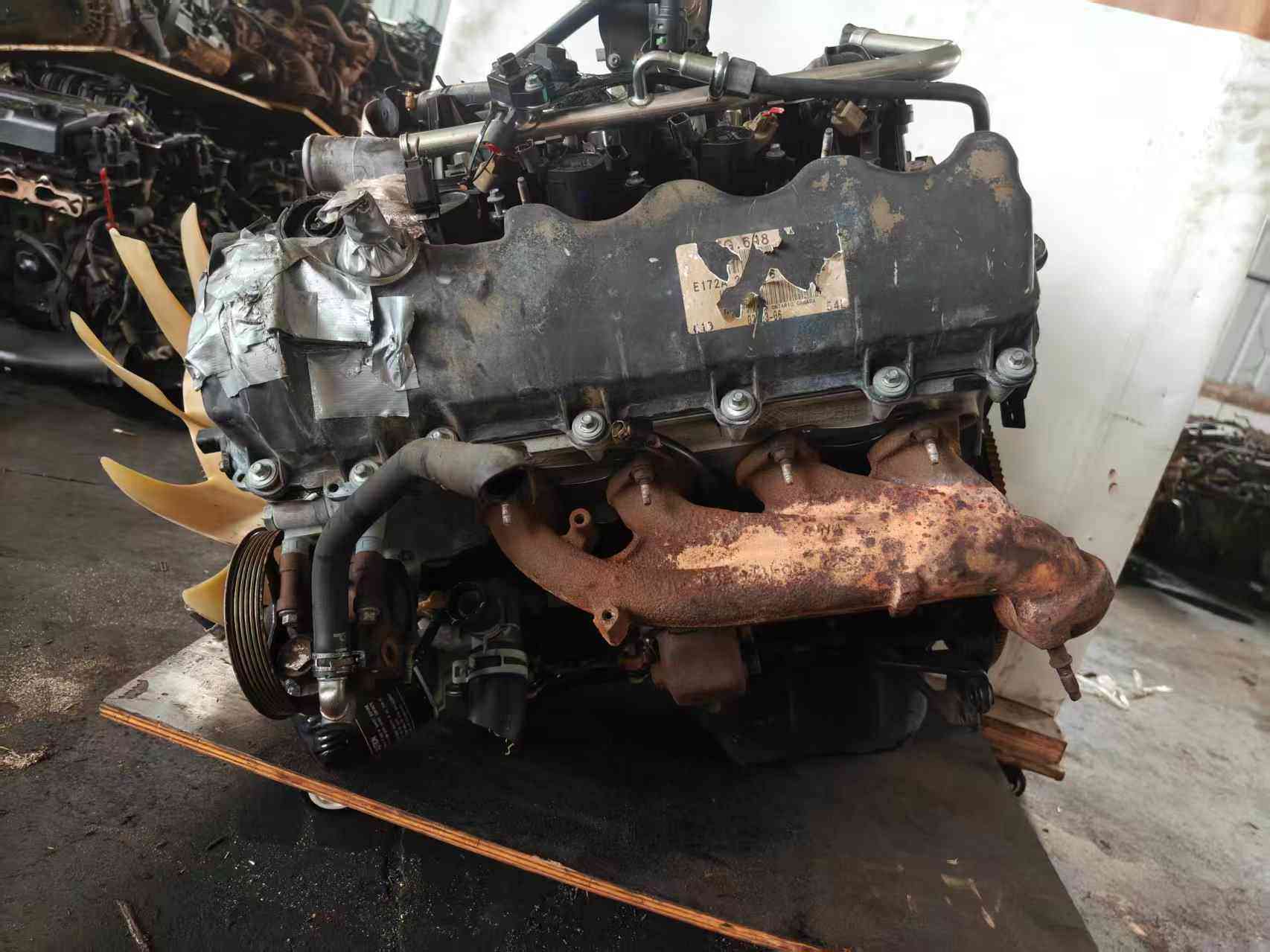 Ford 5.4 Duratec V8 engine exhaust side with valve cover and rusted manifold