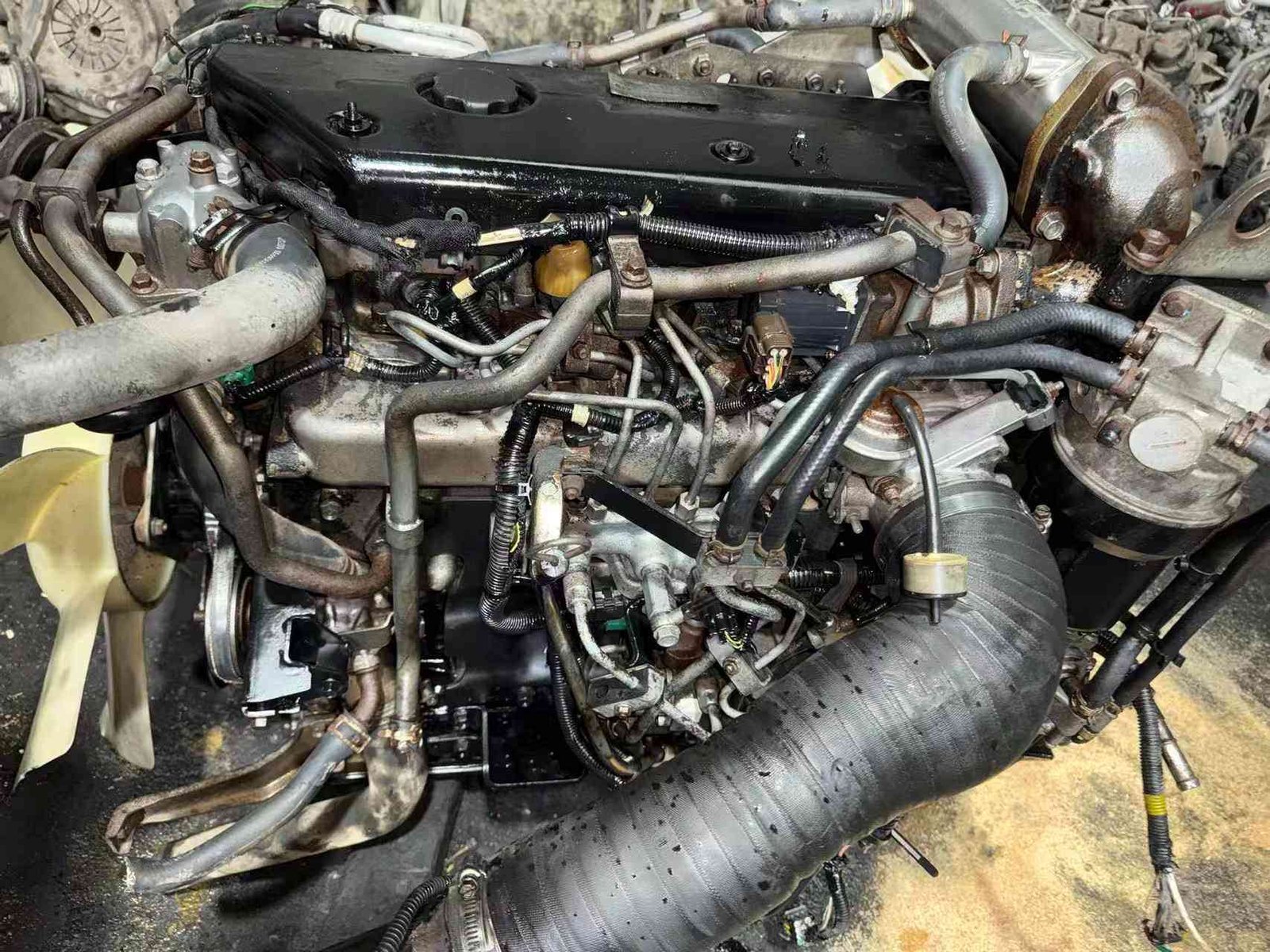Isuzu 4HK1 truck engine rear view with flywheel, clutch and starter motor