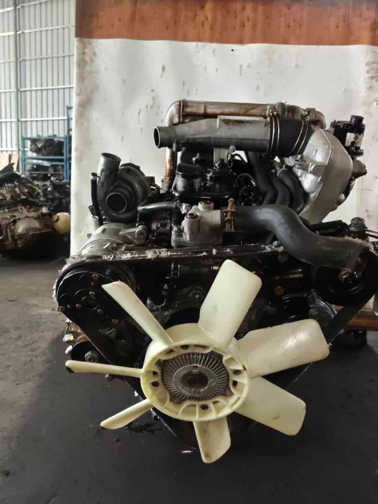 Isuzu 4JB1T turbo diesel engine front view with cooling fan and intercooler piping