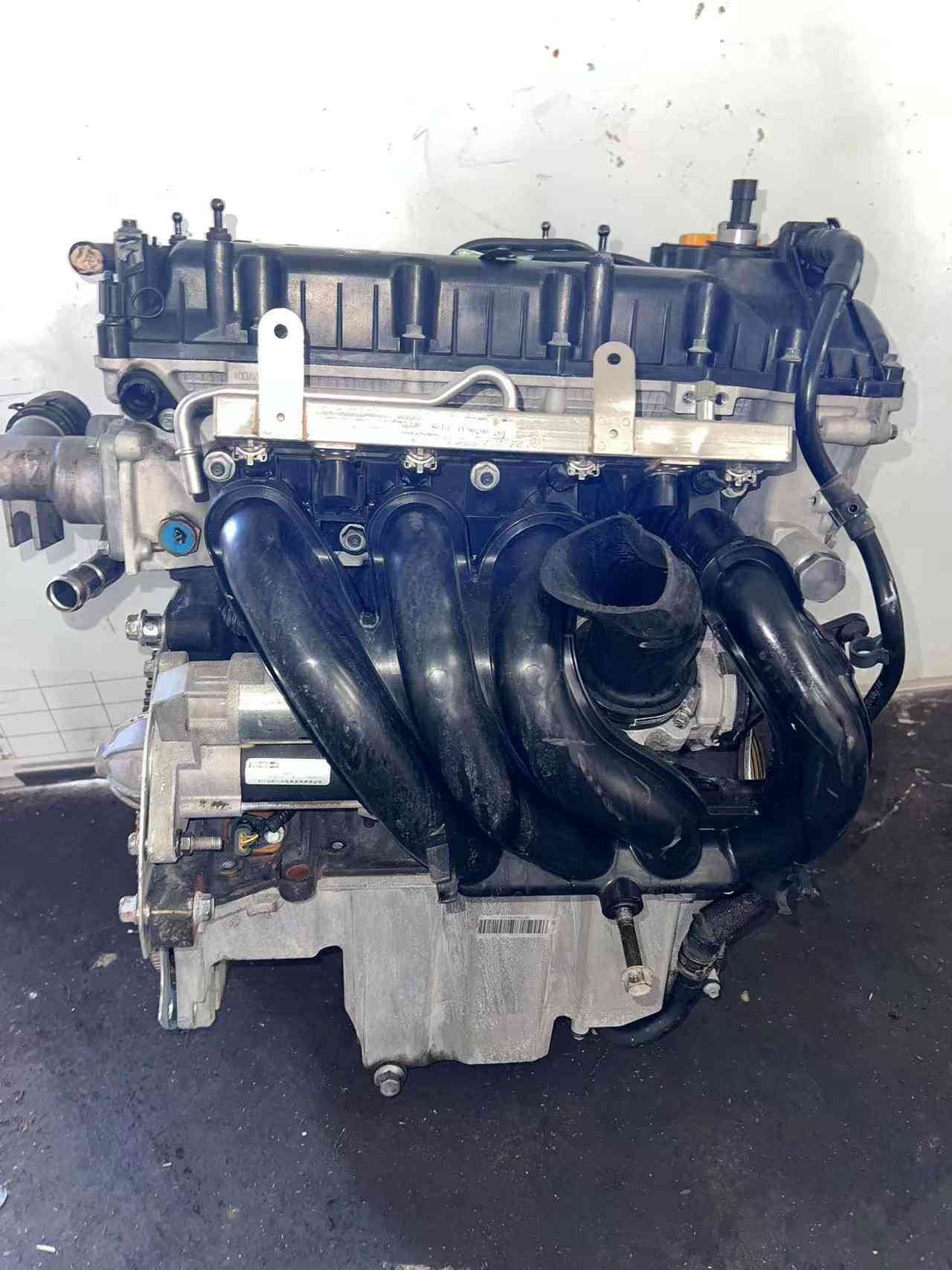 Showcase of genuine spare parts for the MG ZS 15S4U engine, including sensors and wiring harness.