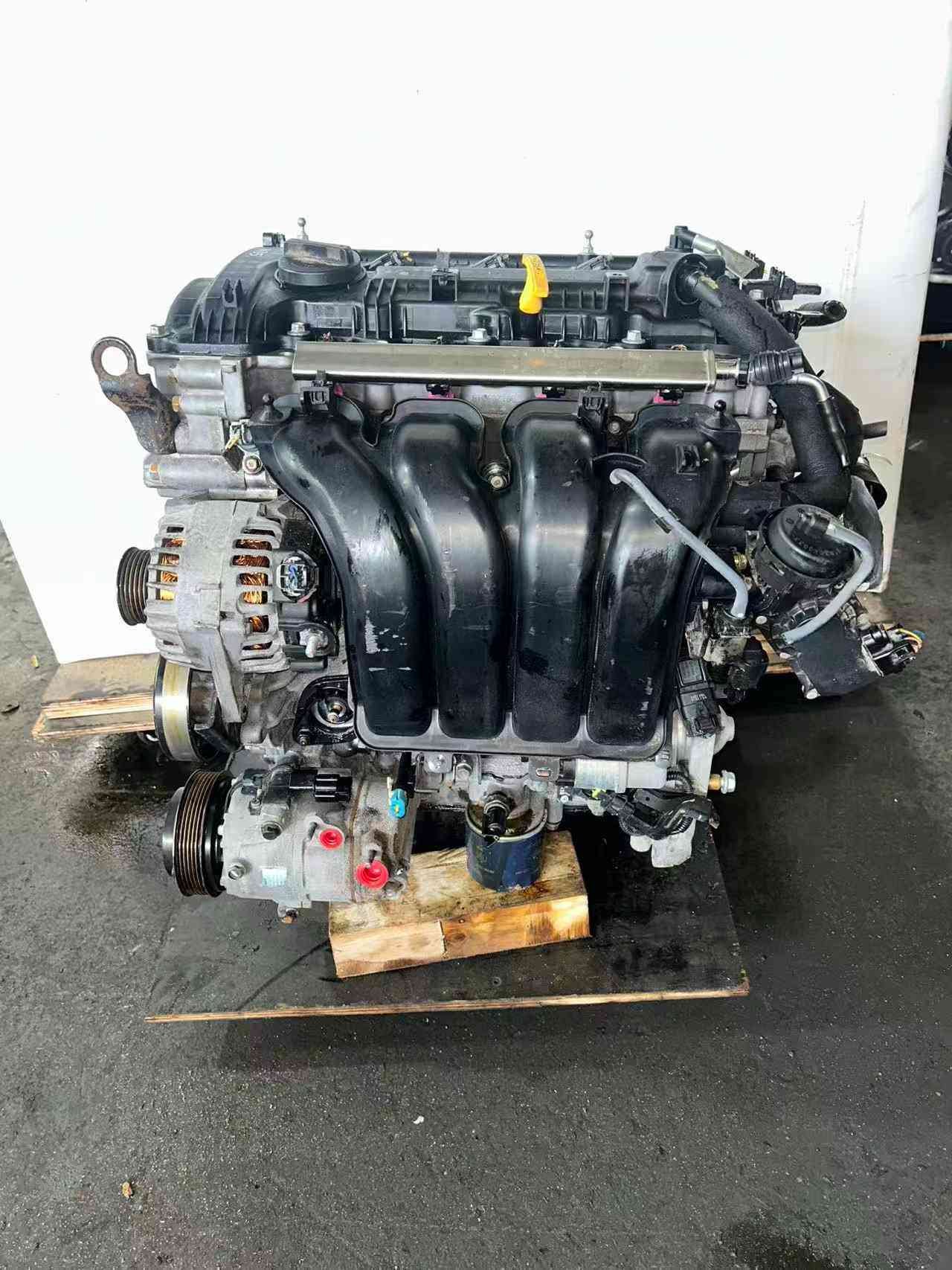 Genuine used Hyundai Elantra 1.8L Nu engine (G4NB) intake and AC compressor side view for sale - alternator and dipstick visible
