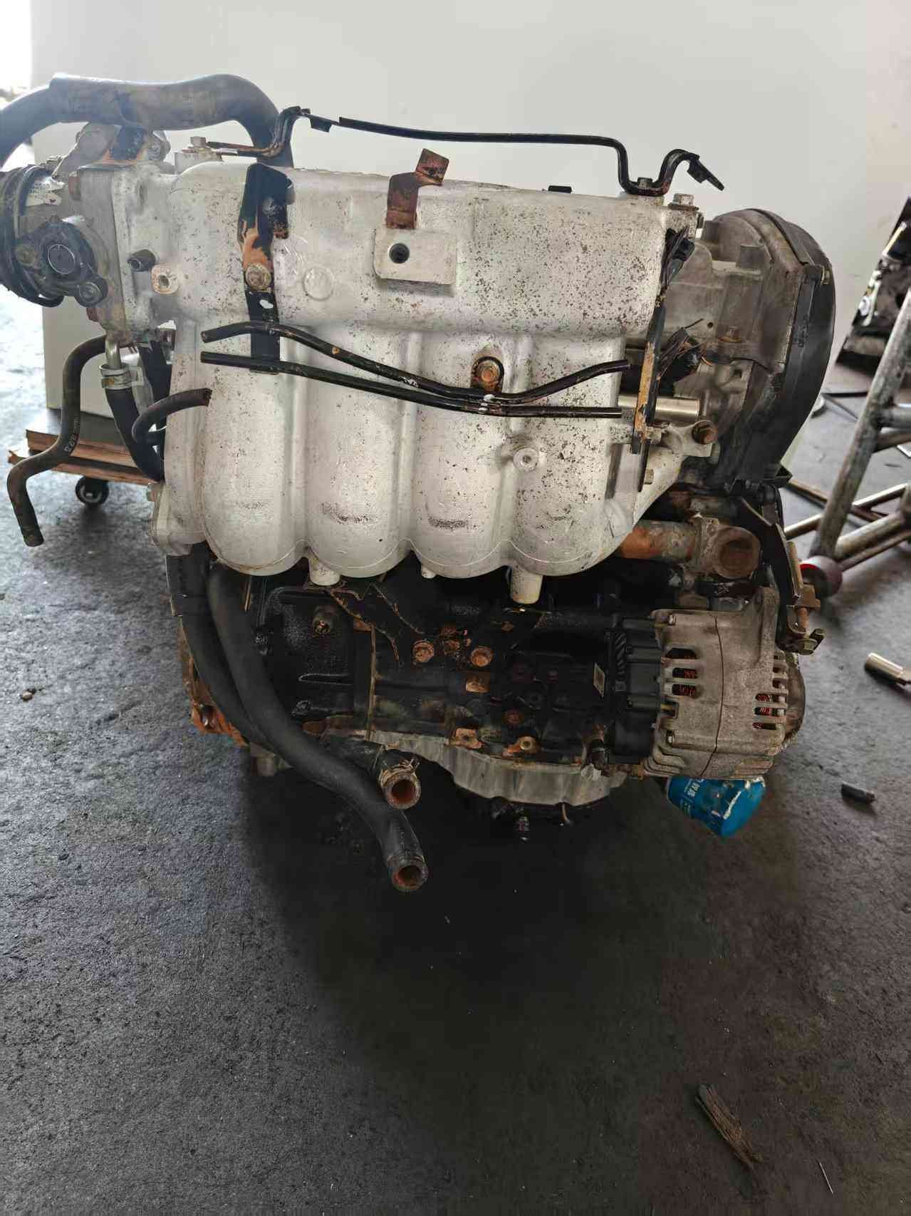 Genuine used Hyundai Sonata 2.0L Sirius II engine (G4JP) intake manifold and alternator side view for sale - cast intake manifold and oil filter