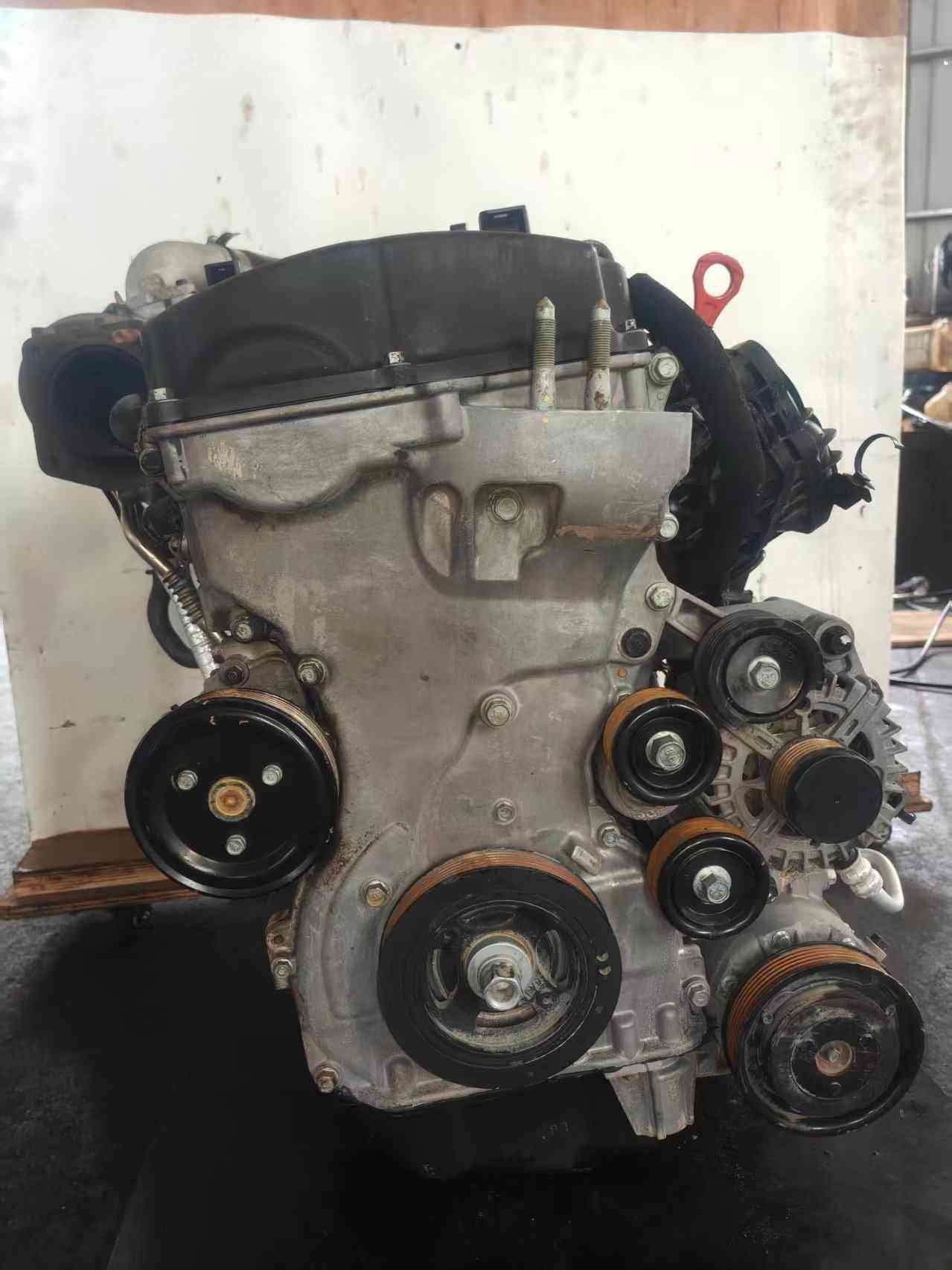 Genuine used Hyundai Sonata 2.0L turbo GDI engine (G4KH) front view for sale - black valve cover, lifting eye and belt pulleys