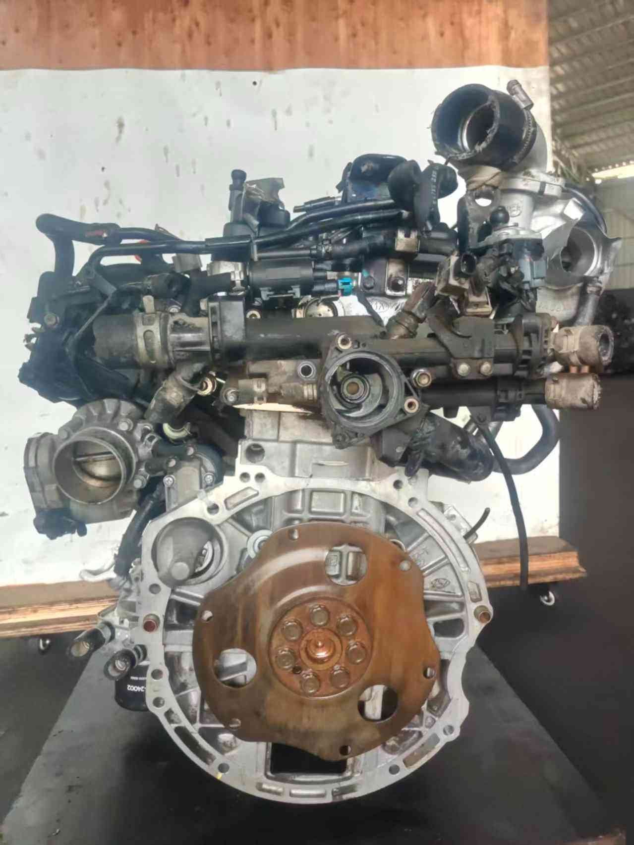 Genuine used Hyundai Sonata 2.0L turbo GDI engine (G4KH) turbocharger and flywheel angle for sale - throttle body visible