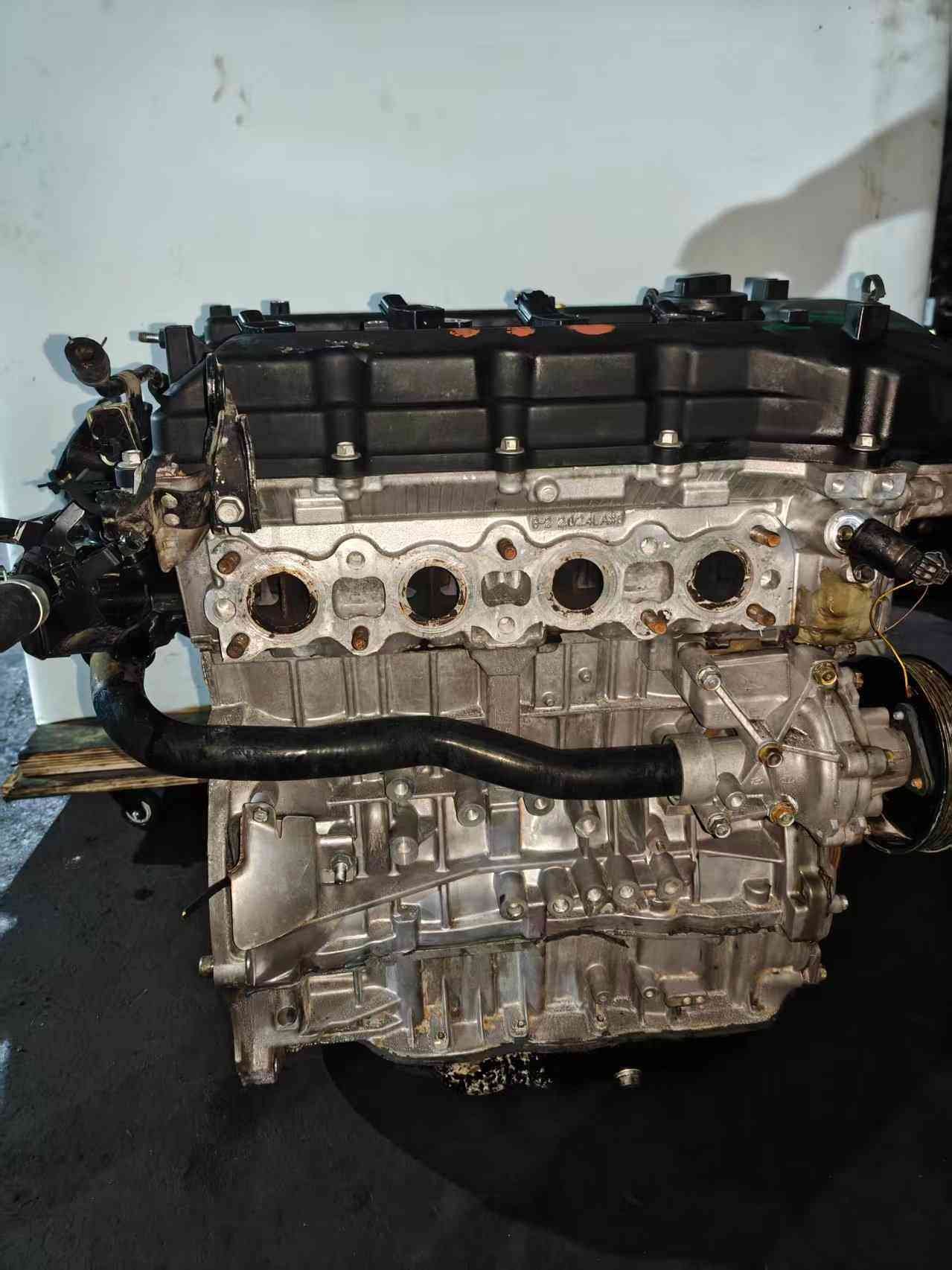 Genuine used Hyundai Sonata 2.4L Theta II engine (G4KE) engine block side view for sale - exhaust manifold ports and water pump