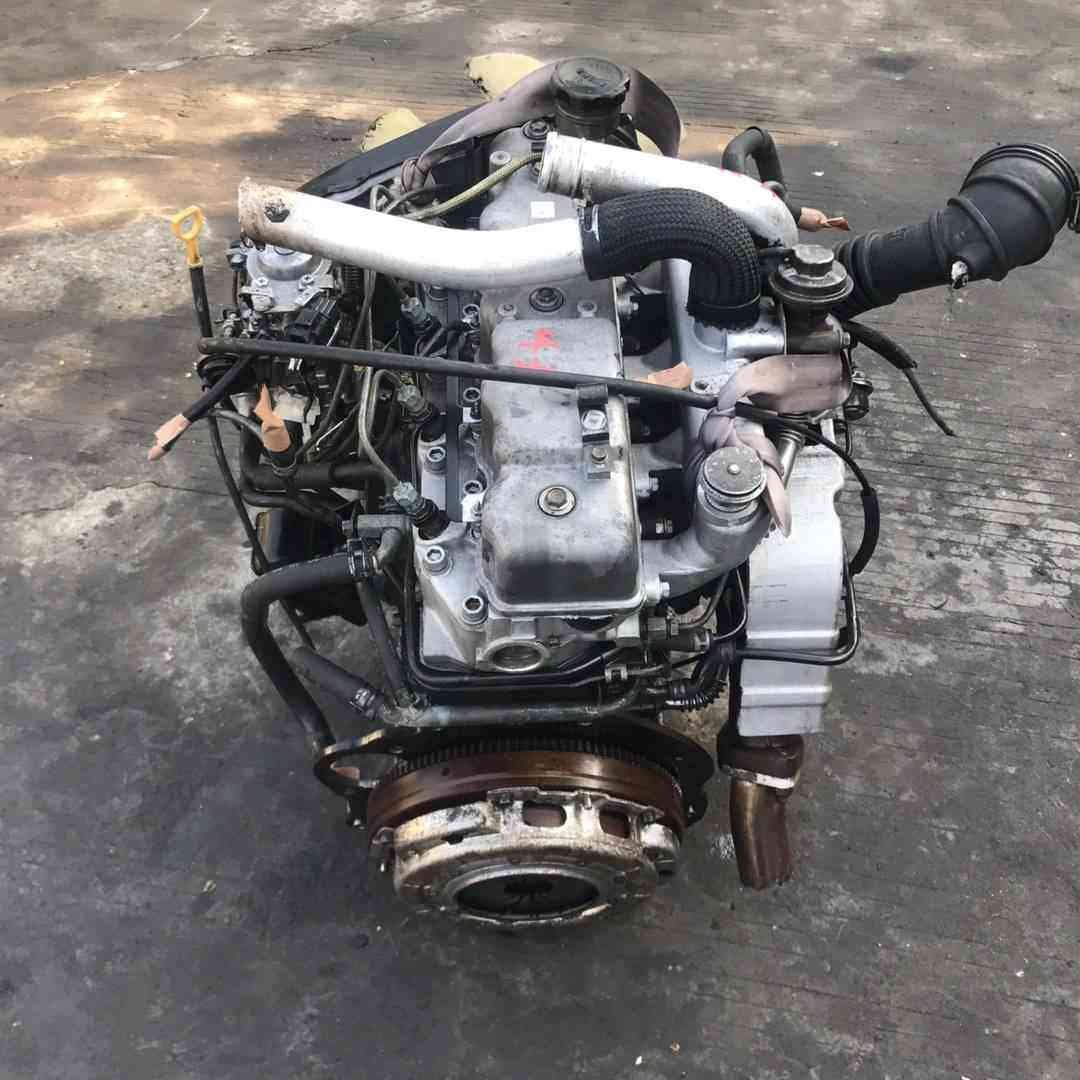 Genuine used Hyundai Starex 2.5L TCI turbo diesel engine complete assembly (D4BH) front view for sale - engine block, intake and mounting brackets visible