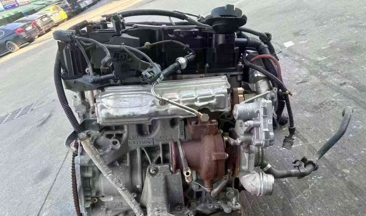 BMW N47 complete used engine assembly showing the turbocharger, wiring harness, and exhaust-side components