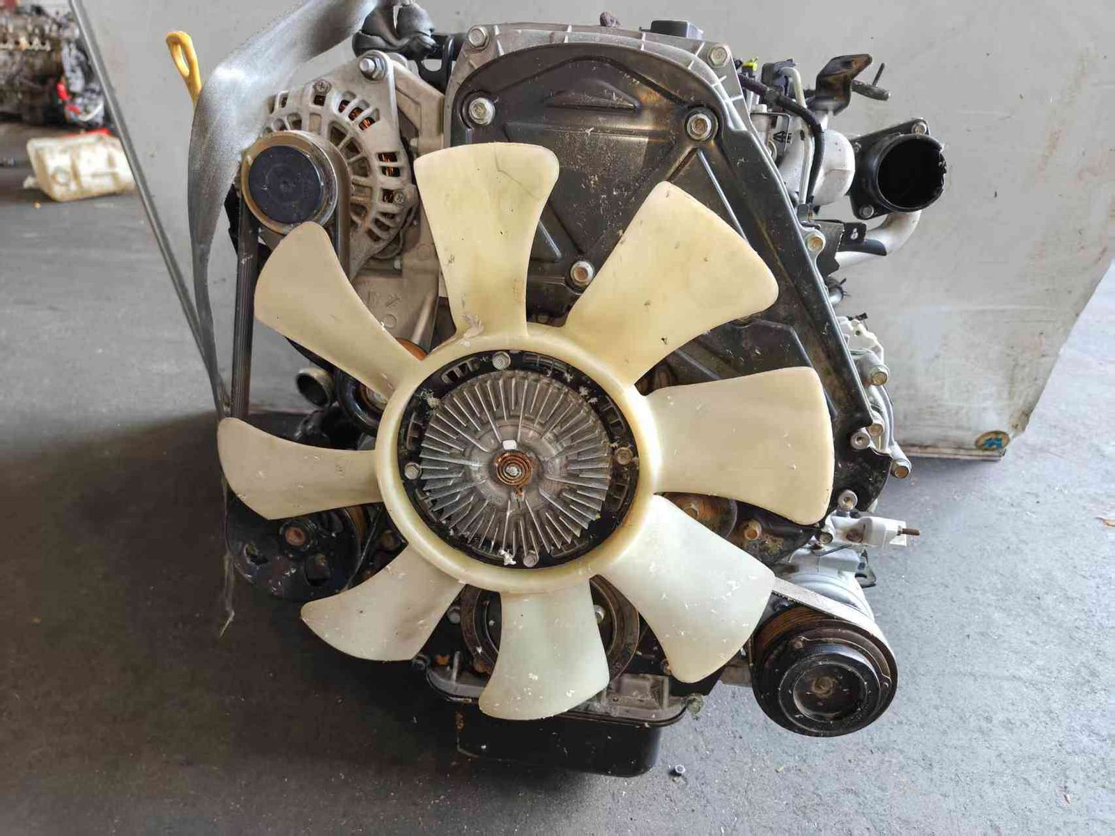 Hyundai Kia D4CB used engine front view with cooling fan, belts and accessory pulleys