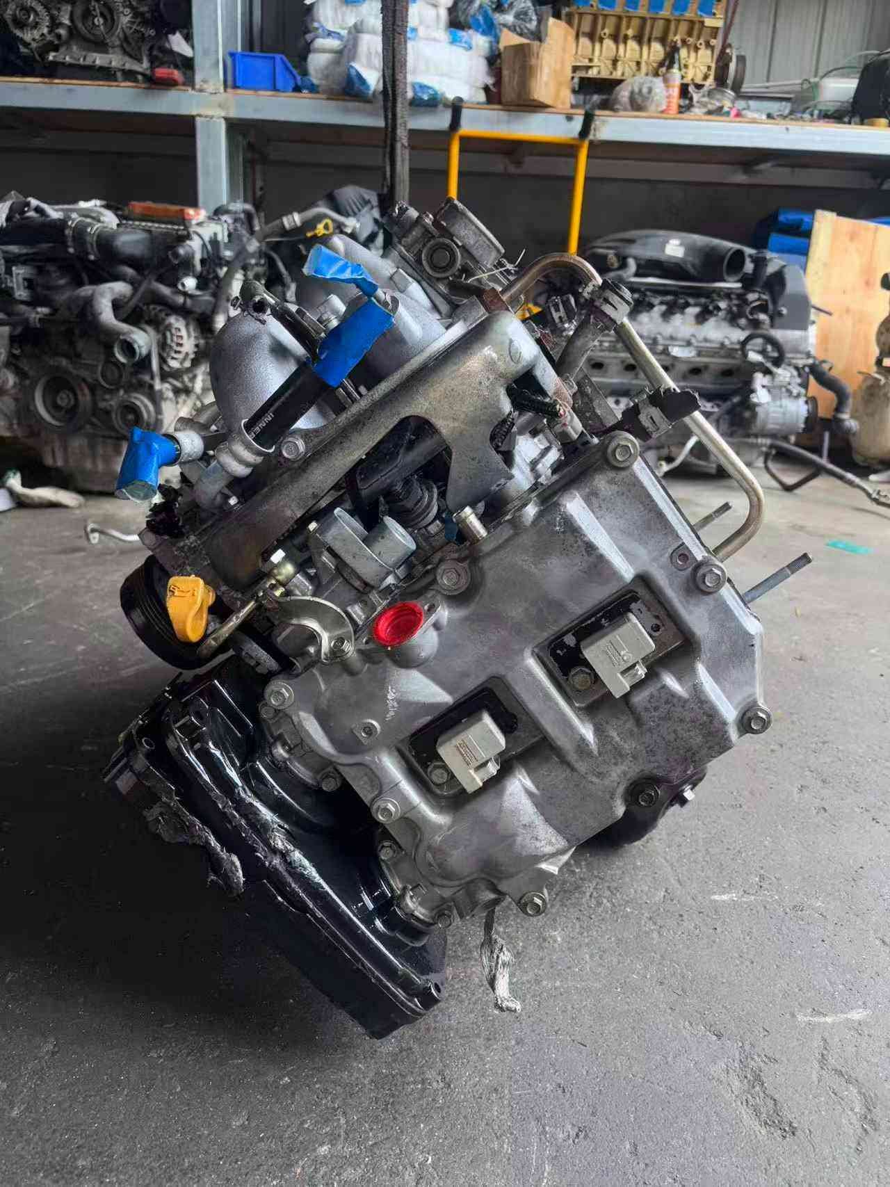 Subaru EJ20 engine assembly angled side view with valve cover, oil dipstick and electrical connectors