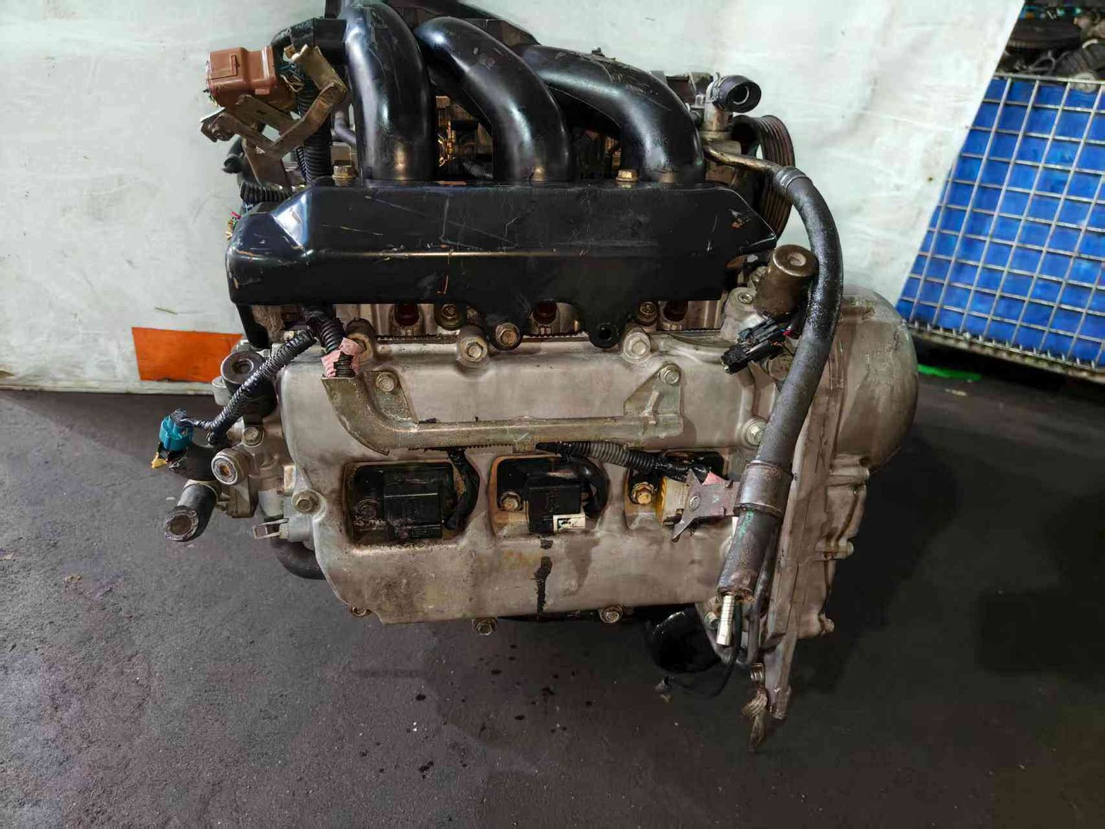 Subaru EZ30 engine assembly side view with black intake manifold, valve cover and ignition coil connectors