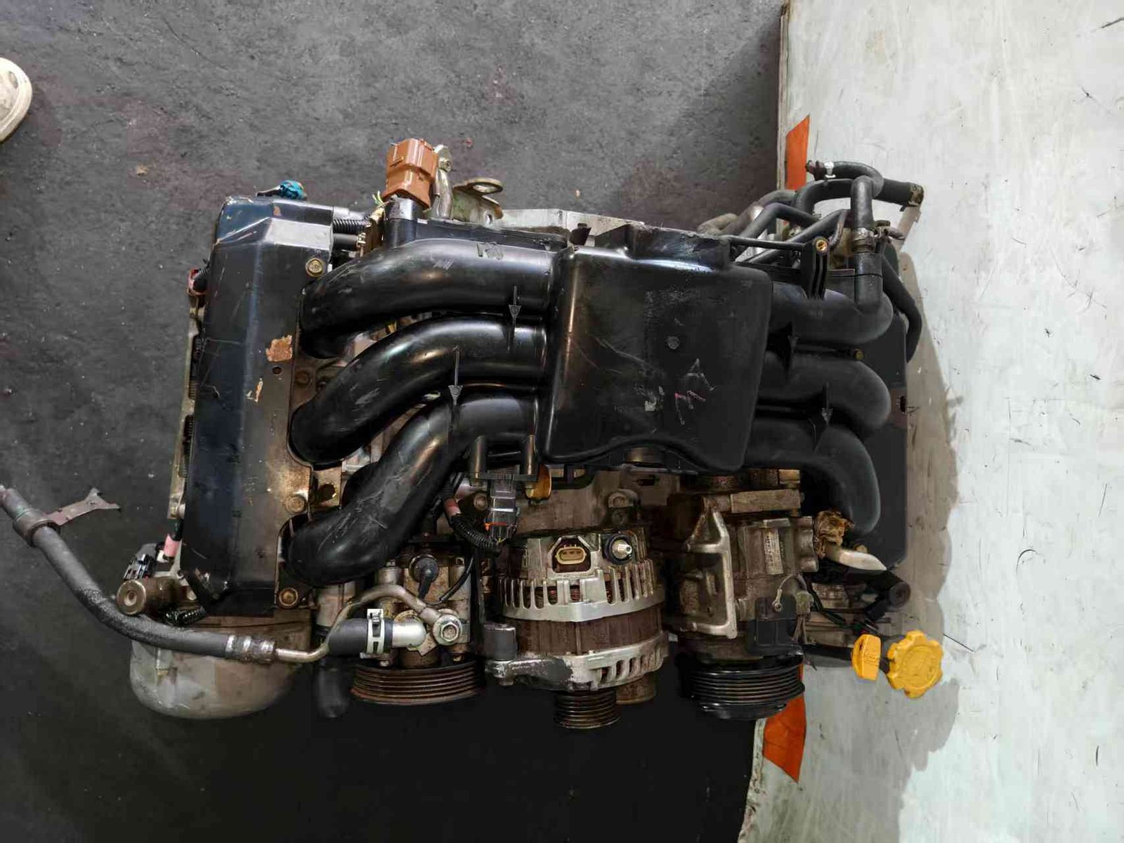 Subaru EZ30 engine assembly top view with intake manifold, alternator and accessory belt pulleys