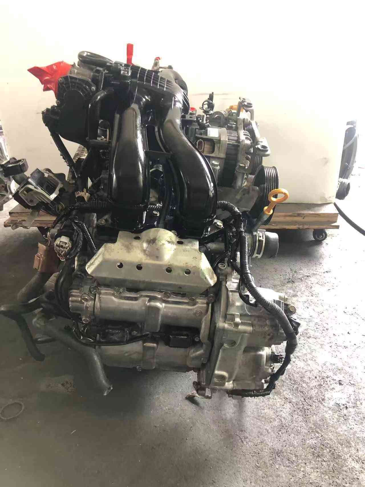 Subaru FB20 engine assembly side view with intake manifold, heat shield, wiring harness and oil dipstick