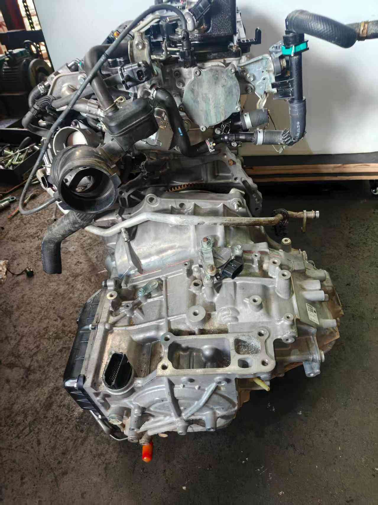 Toyota A25A powertrain rear view with transmission casing and coolant hoses