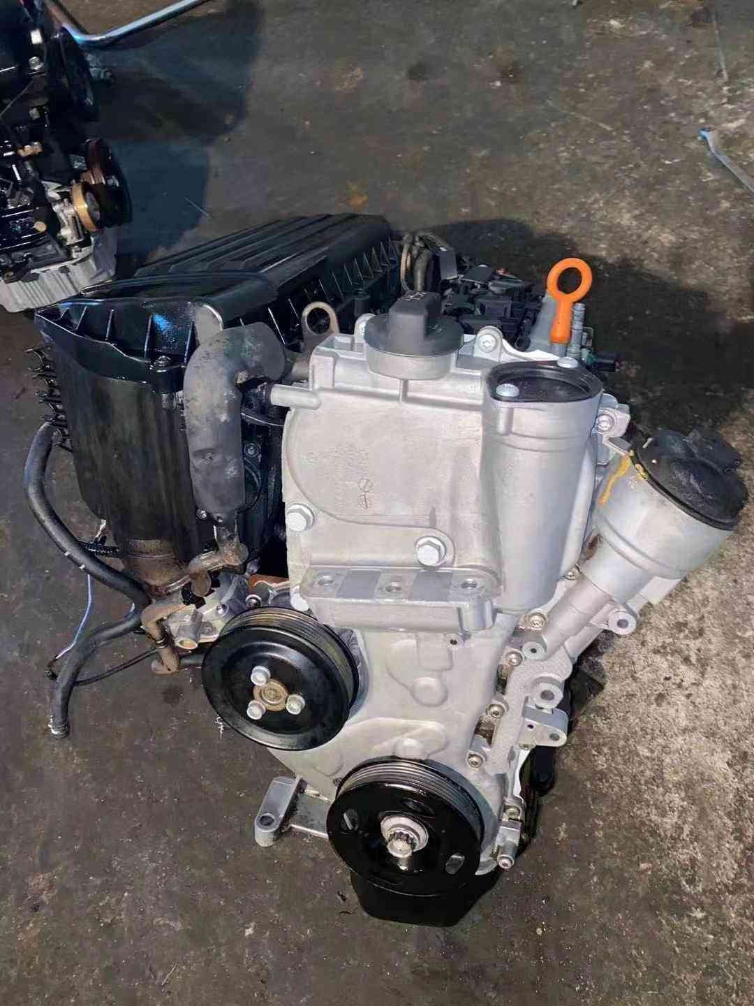 Volkswagen EA111 CDE engine front view with accessory pulleys, oil filter housing, and exposed exhaust ports.