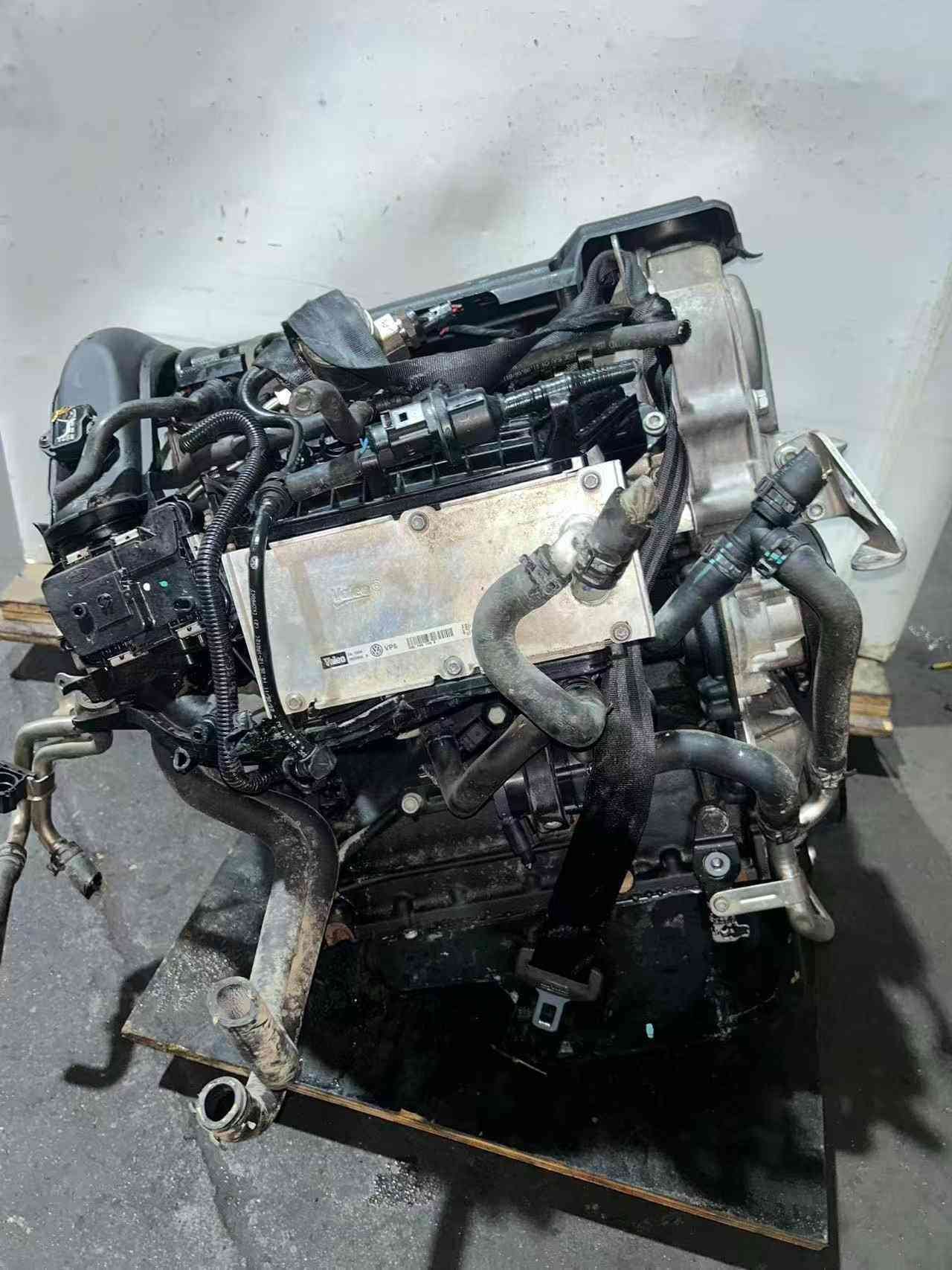 Volkswagen EA111 CFB engine assembly showing the side-mounted electronic control module, hoses, and wiring connectors.