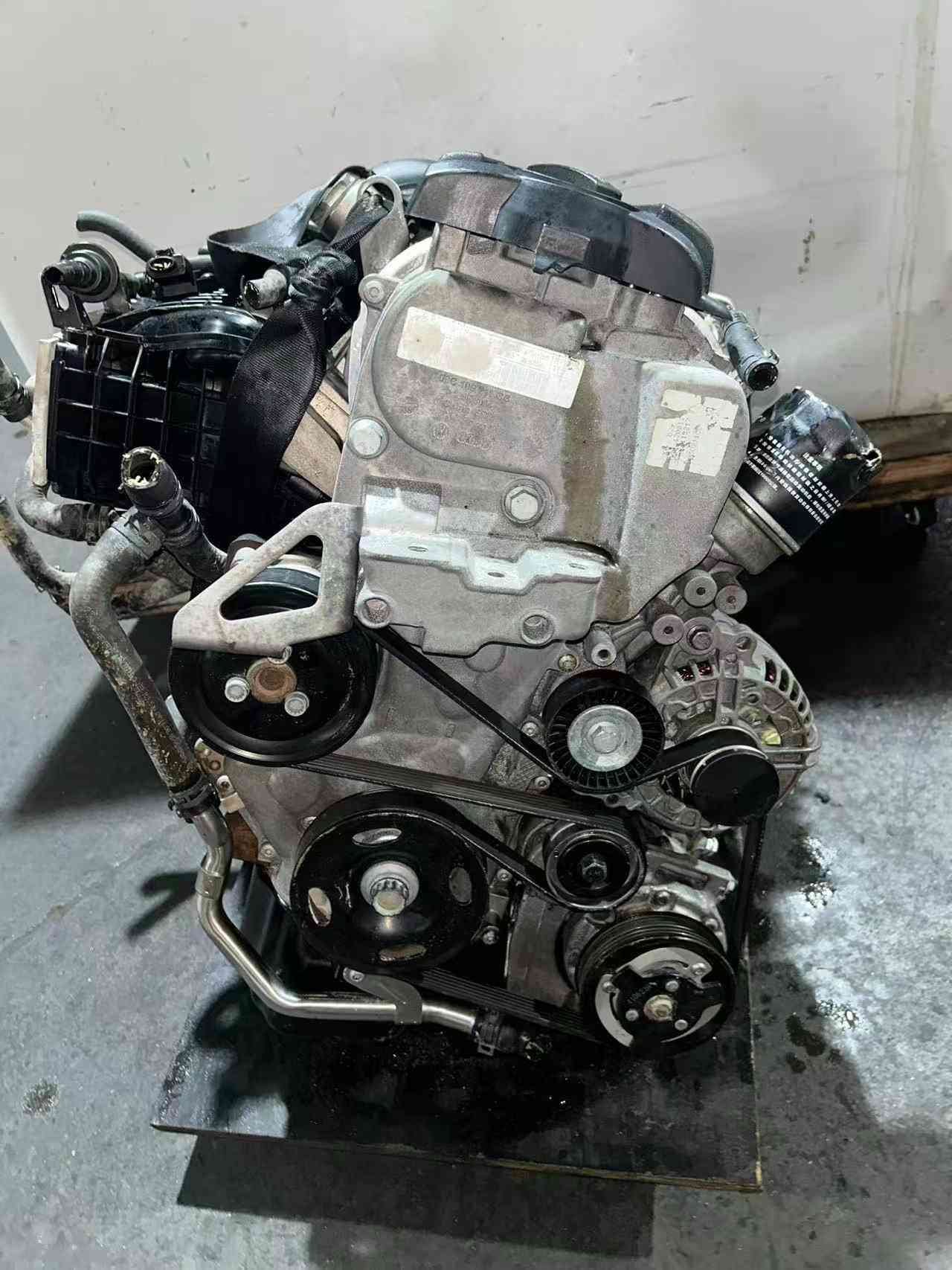 Front accessory-drive view of a Volkswagen EA111 CFB engine with belt pulleys and alternator.