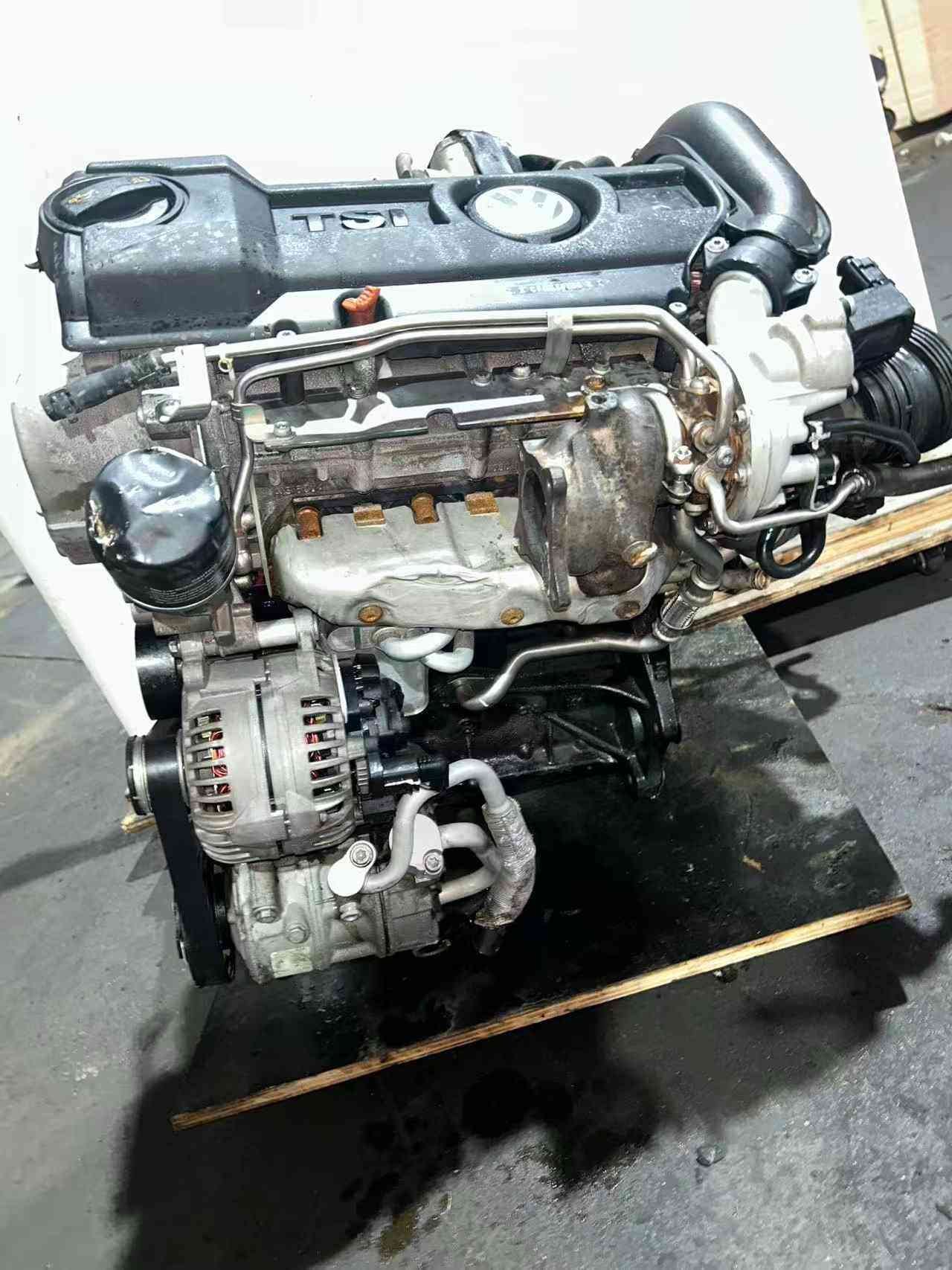 Volkswagen EA111 CFB TSI engine side view with VW-branded engine cover, turbocharger, and alternator.