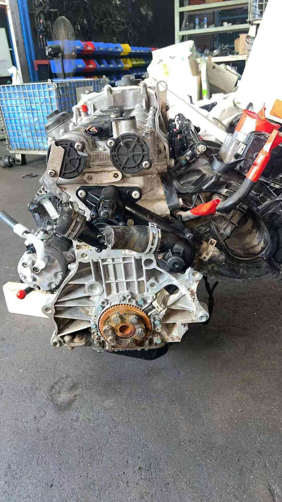 Volkswagen EA111 CLP engine flywheel-side view with transmission mounting flange, coolant hoses, and wiring connectors.