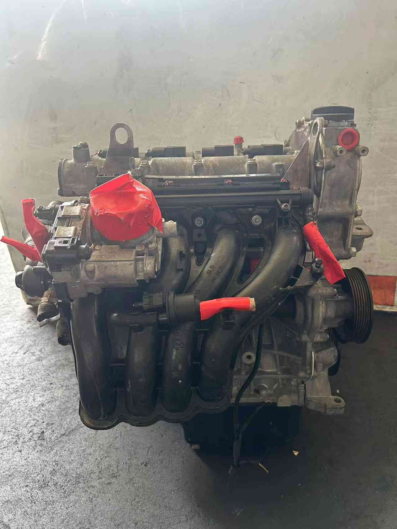 Front view of a Volkswagen EA111 CLP engine with black intake manifold runners and protected hose connections.