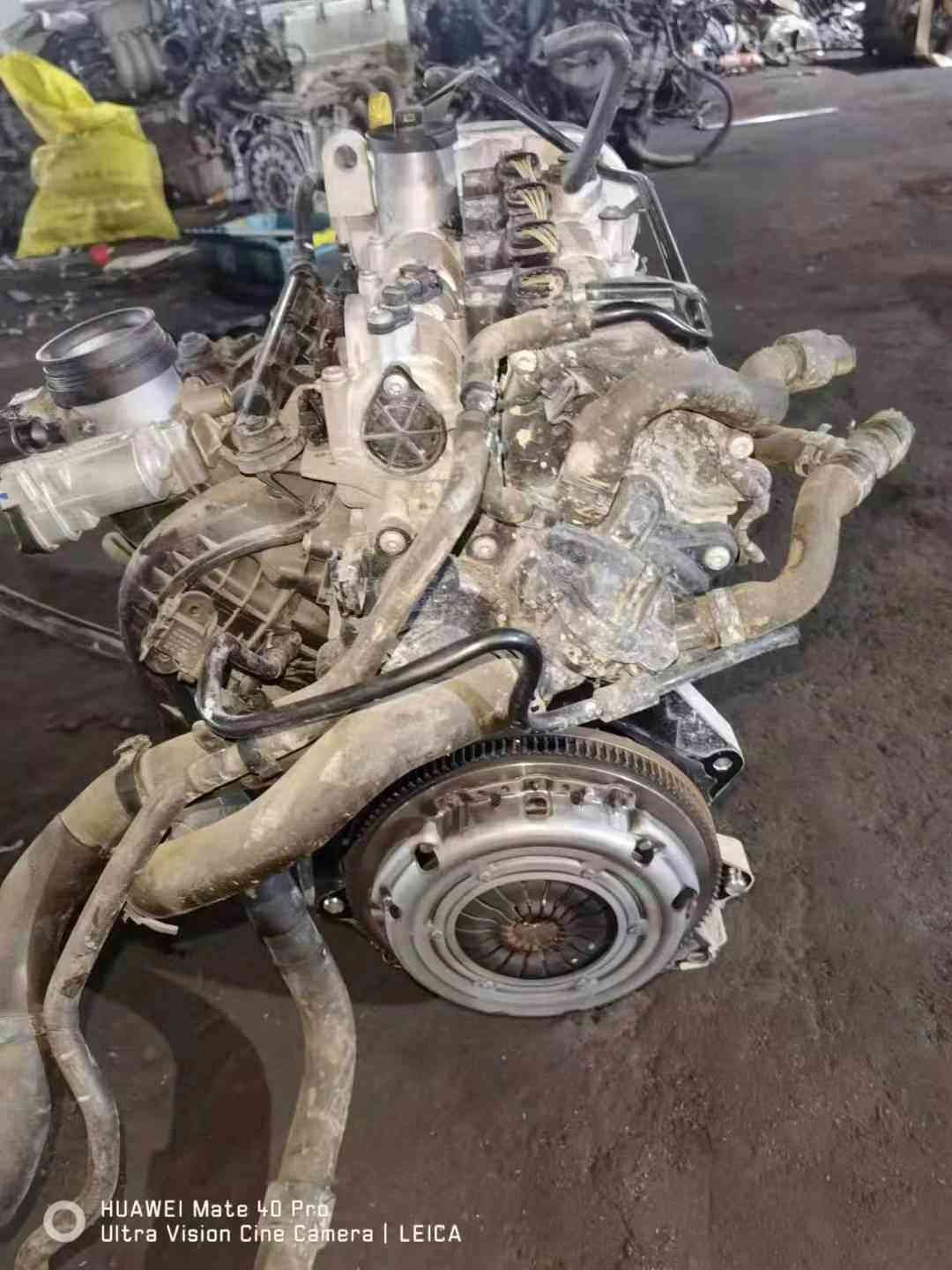 Volkswagen EA211 CKA engine clutch-side view with pressure plate, flywheel, coolant hoses, and intake assembly.