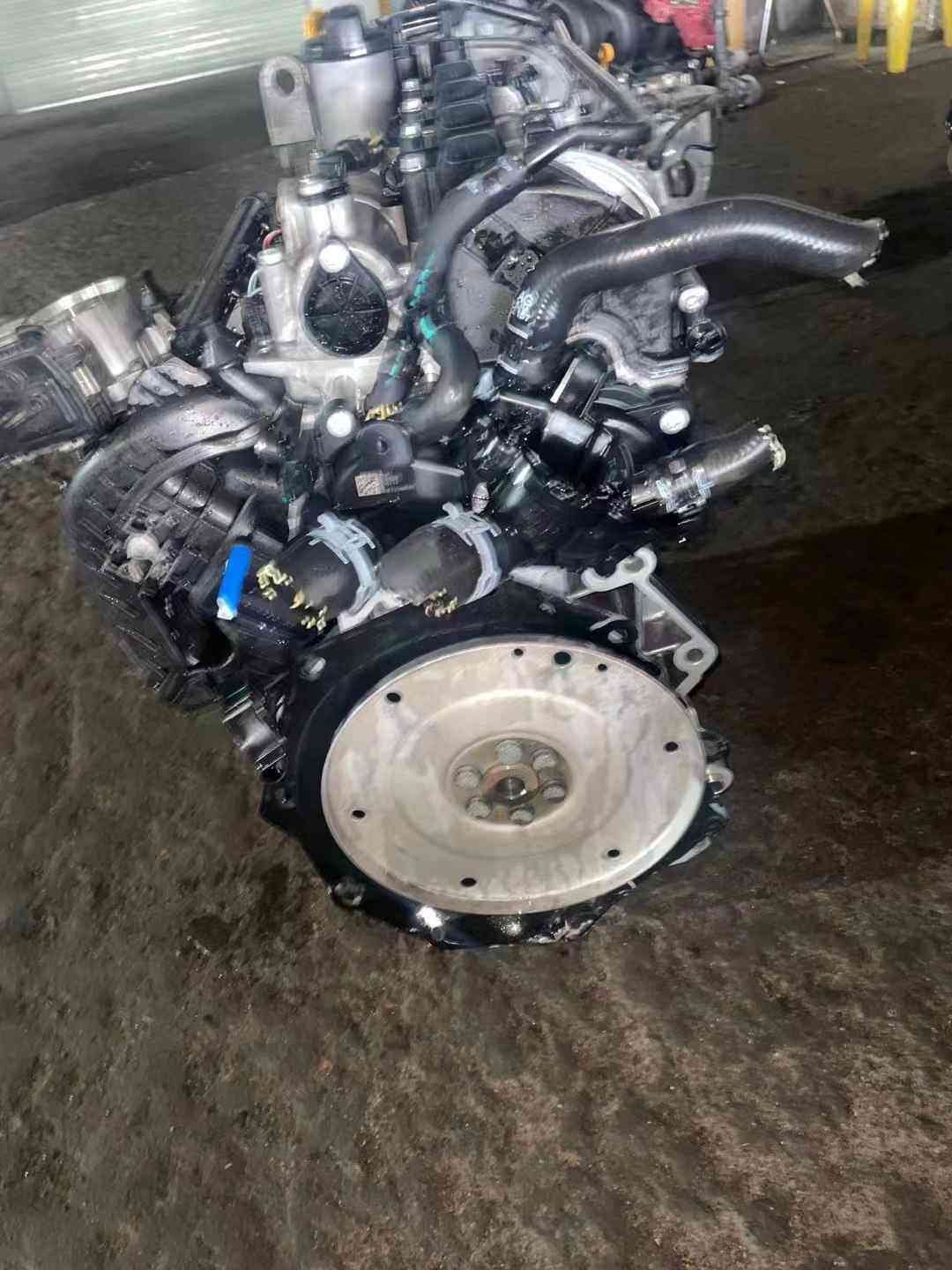 Volkswagen EA211 CSR engine flywheel-side view with intake hoses, engine wiring, and circular transmission mounting face.