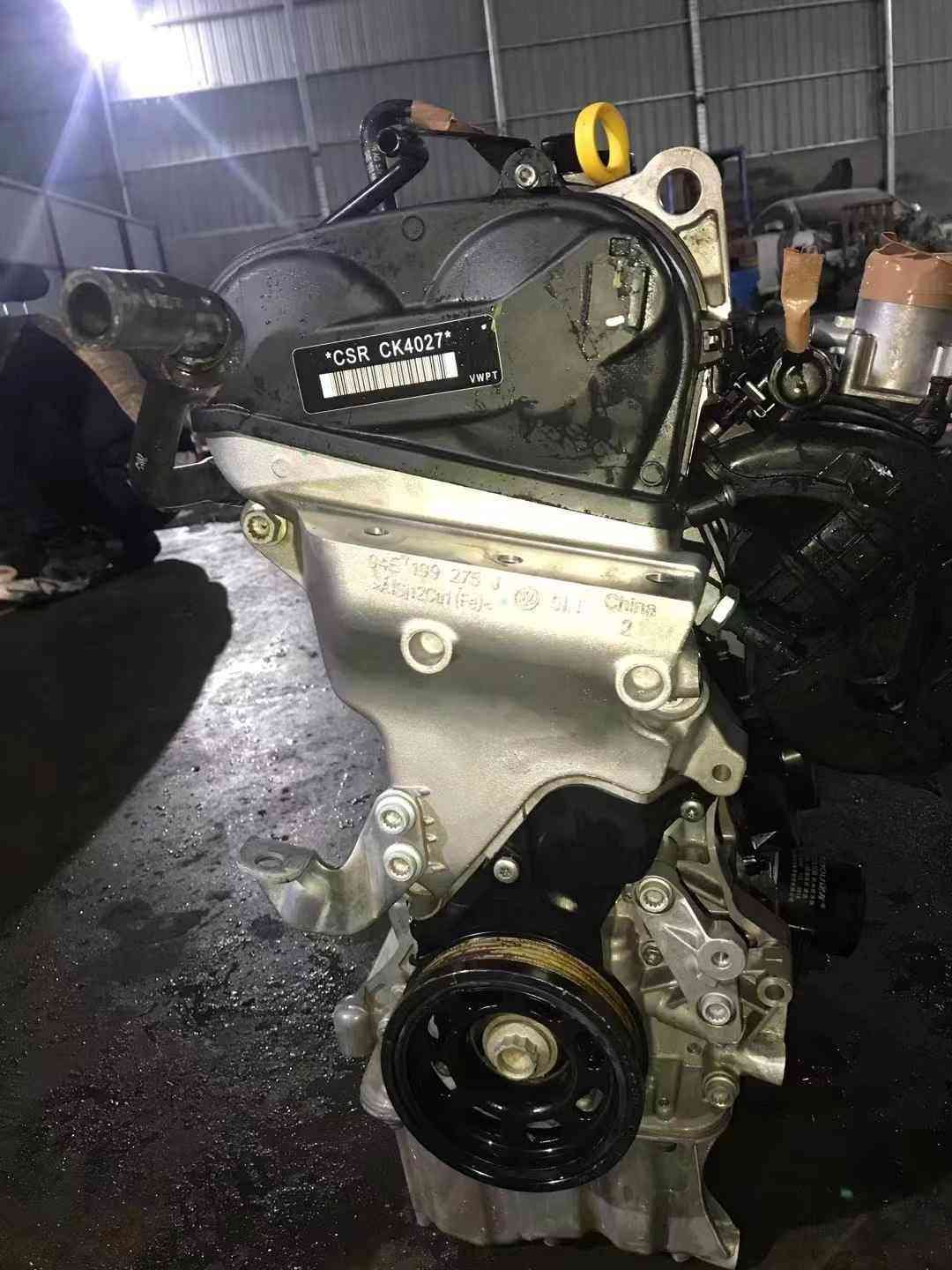 Close view of a Volkswagen EA211 CSR engine timing-cover side with engine code label, dipstick, and crank pulley.
