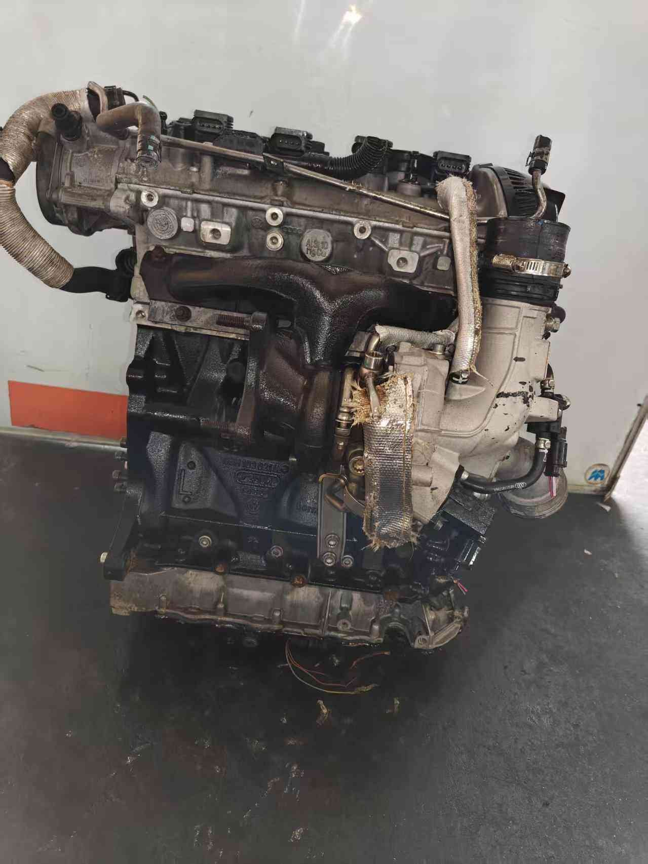 Exhaust-manifold side of a Volkswagen EA888 Gen 2 CDA engine with turbocharger, heat shielding, and intake pipe connection.