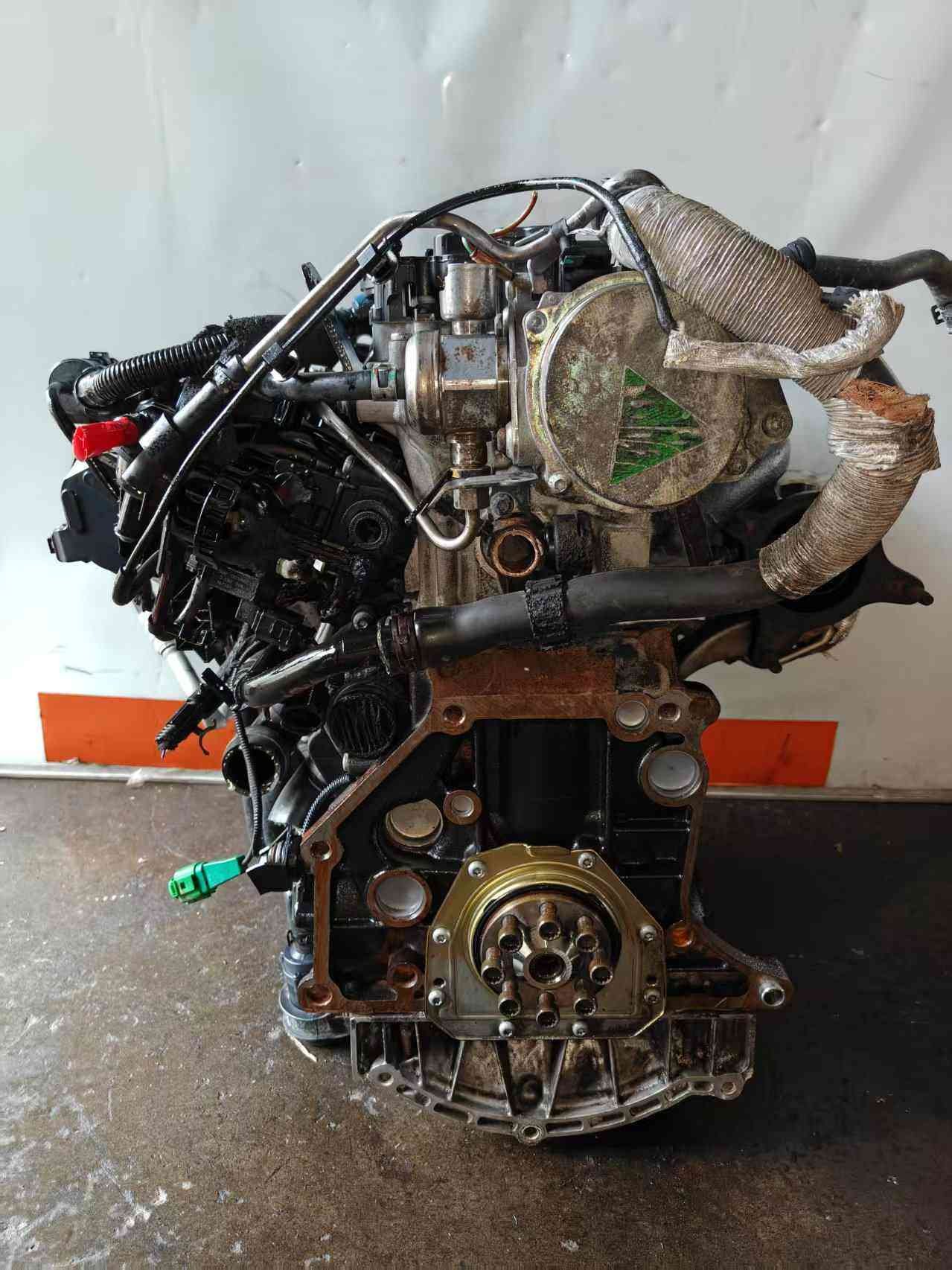 Rear view of a Volkswagen EA888 Gen 2 CDA engine showing turbocharger piping, heat-wrapped exhaust components, and flywheel mounting face.