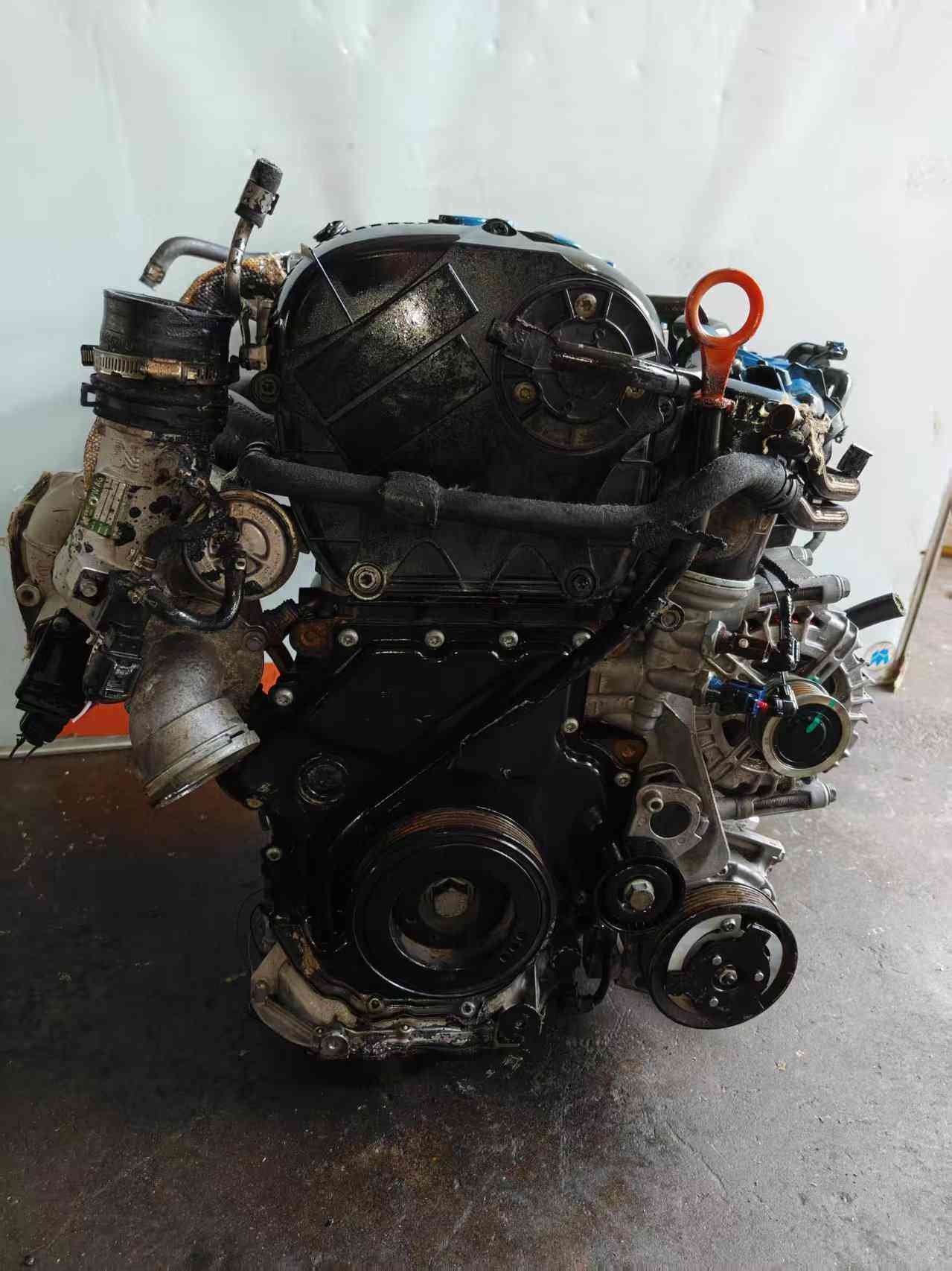 Volkswagen EA888 Gen 2 CDA engine timing-cover side with orange dipstick, crank pulley, and accessory-drive components.