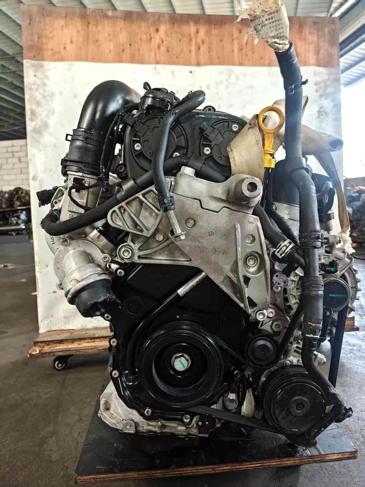 Volkswagen EA888 Gen 3 CHH engine front view with accessory pulleys, intake tubing, engine mounts, and oil dipstick.